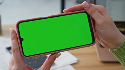 Entrepreneur video calling chroma key cellphone in modern light office closeup