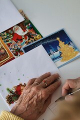 An elderly woman writing Christmas cards
