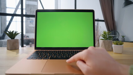 Fototapeta premium Freelancer hand swiping greenscreen laptop in office closeup. Woman scrolling 