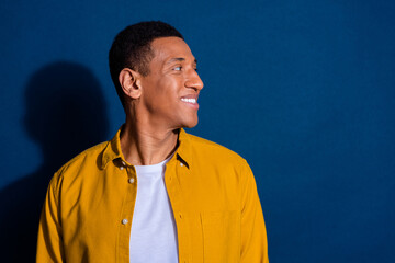 Obraz premium Side profile photo of young student man wearing stylish shirt with new haircut looking novelty smiling isolated on dark blue color background