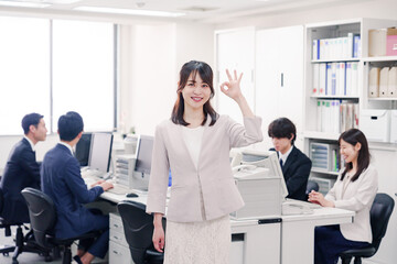 オフィスでOKサインをする若い女性社員