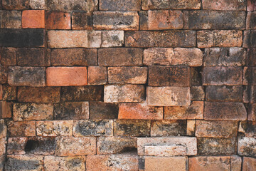 Old red black stone brick wall made with antique blocks for abstract seamless background and texture. beautiful patterns, space for work, close up.