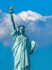 Fototapeta premium Close up of the world famous Statue of Liberty under a blue sky with clouds
