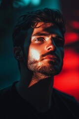 Fototapeta premium A silhouette of a man with strong shadows on his face creating a dramatic and mysterious mood in dim lighting.