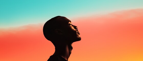  A man's silhouette faces sideways against an orange-blue sky