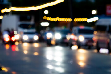 A blurry image of a busy street at night with cars and trucks. The lights from the vehicles are...