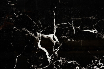 A black and white photo of a marble floor with white streaks. The photo has a moody and dramatic feel to it, with the black and white tones emphasizing the contrast between the marble