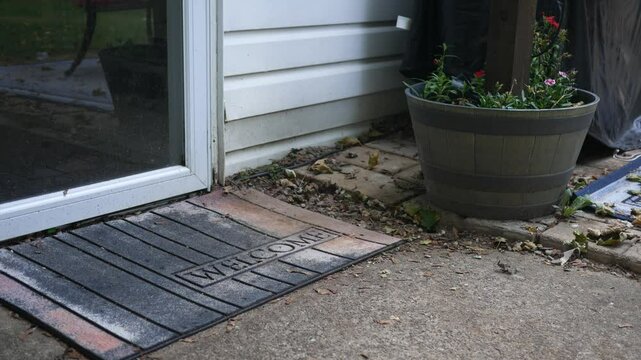 A Porch Pirate runs and grabs a package near a residential home