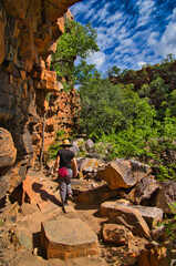 Female hiker descending into The Grotto, a deep waterhole at the end of a small gorge along the highway from Kununurra to Wyndham, in the north of Western Australia.
