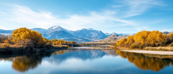 Naklejka premium A bridge spans a body of water, surrounded by a mountain range and cloud-specked sky