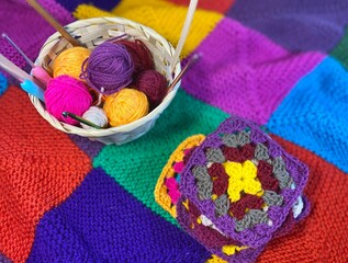 Crochet granny square motives set on the table, clews and hooks and basket cozy home photo