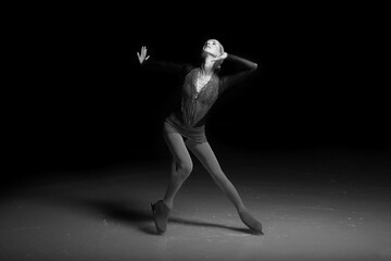 woman figure skater posing on dark background