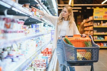 Young woman looking at product at grocery store. Costumer buying food at the market
