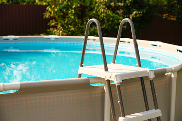 Above ground swimming pool outdoors on sunny day