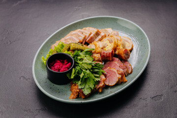 Appetizing meat platter with pickles, herbs and beetroot dip, perfect for traditional gourmet dining