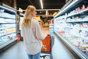 Portrait Of Smiling Woman With Shopping Cart In Supermarket Buying Groceries Food