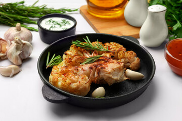 Fototapeta premium Delicious baked cauliflower steaks served on white tiled table