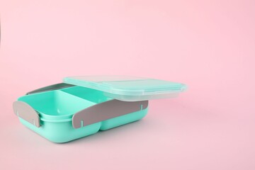 Empty plastic lunch box on light pink background. Space for text