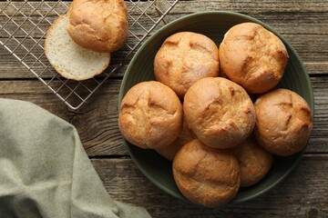 Homemade tasty buns on wooden table, flat lay