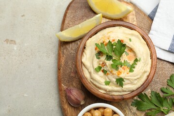 Delicious hummus with parsley, paprika, garlic and lemon on grey table, top view