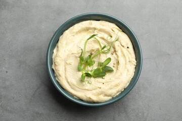 Delicious hummus in bowl and pita on grey table, top view