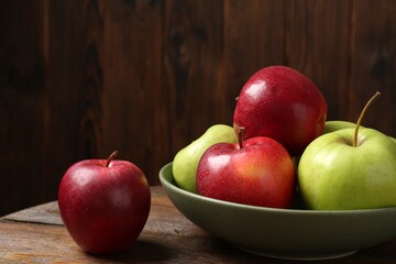 Fresh red and green apples on wooden table, closeup