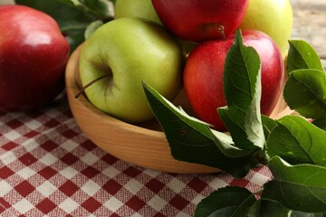 Ripe apples and green leaves on table, closeup