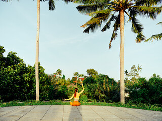Woman relaxing on beach with frisbee in hand, enjoying sunny day under palm tree