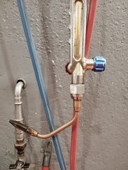 welding torch with pipes and pressure reducers on a workshop wall. Industrial equipment