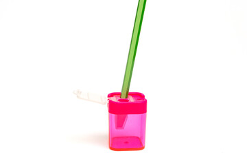 Fototapeta premium A pink container with a green pencil sticking out of it. The pencil is green and has a green handle
