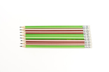 A row of pencils with green, red and white stripes. The pencils are lined up next to each other. Pencils isolated on white background.