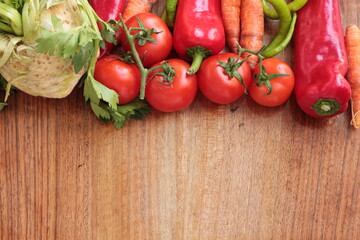 Tomato, green pepper, red capia pepper, carrot, celery. Fresh healthy colorful raw vegetables on the wooden background with Copy space for text. Ingredients for preparing vegetable dishes