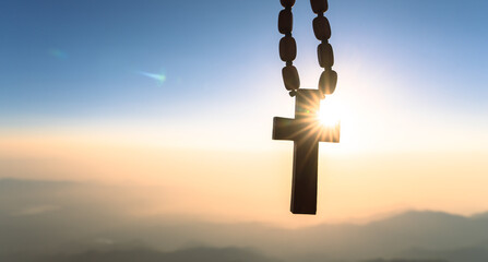 Wooden cross on the background of sunset, sunlight