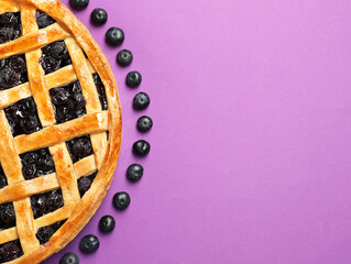 Tasty homemade pie with blueberries on purple table, top view. Space for text
