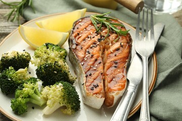 Tasty grilled salmon steak with broccoli served on table, closeup