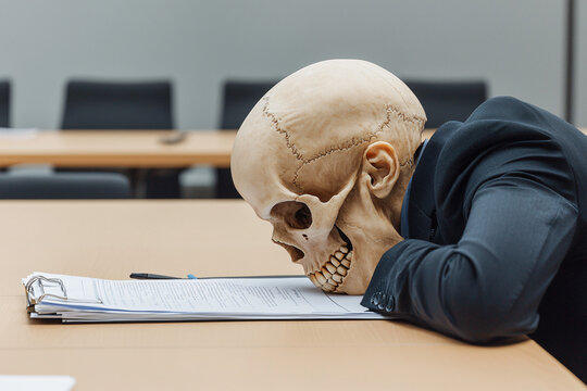 a skull-headed businessperson reviewing documents in a sterile conference room, symbolizing the dehumanizing effects of overwork