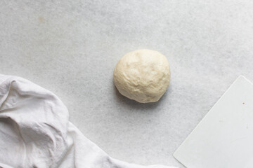 Overhead view of challah dough divided into balls on a white granite countertop, top view of homemade challah dough balls on white countertop, process of making challah