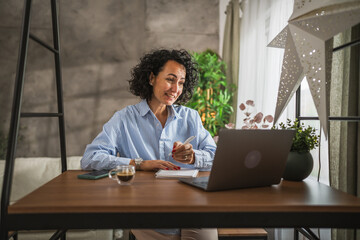 Mature caucasian woman work or learn use notebook and laptop from home