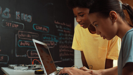 Group of diverse student working together to write program. Multicultural children coding or...