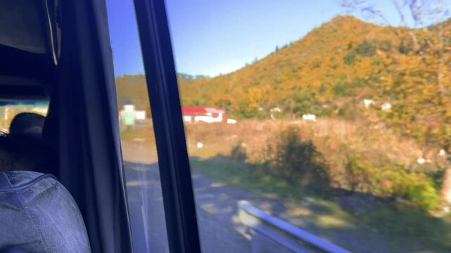 4K video. Road to Tbilisi from Borjomi. Georgia. View from bus window on track, tree, grass, bridge, blue sky out of focus. Minibus taxi. Sunny day. Fragment of car interior, chair. Way. Travel, trip