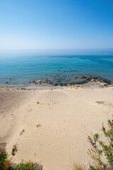 Sandy beach with small rocks, calm sea, clear blue sky, sunny, landscape, Greece, Crete island,...