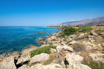 Rocky beach calm shallow water clear blue sky sunny landscape greece crete island wide angle lens