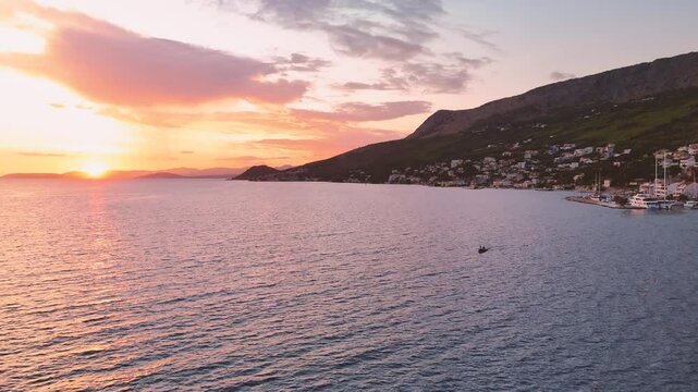 Colorful vived sunset over the sea in Croatia with the silhouette of the riding motor boat 