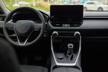 Closeup of a modern car steering wheel with control buttons for technology and convenience