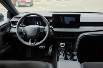 Closeup of a modern car steering wheel with control buttons for technology and convenience