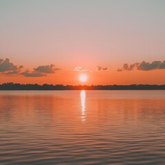 Fototapeta premium A serene sunset over the calm waters, reflecting warm hues of orange and pink, creating a tranquil atmosphere.