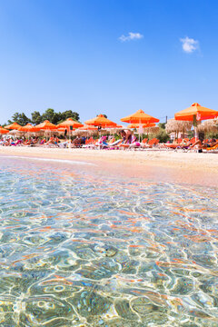 Beach with orange parasols in summer. Kefalonia, Greek Islands, Greece