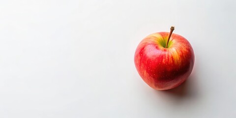 A solitary red apple sits on a pristine white background, its smooth skin glistening under the light. The apple's stem extends upwards, creating a simple yet elegant composition.