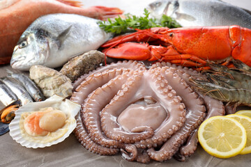 Many different sea food and lemon on grey textured table, closeup