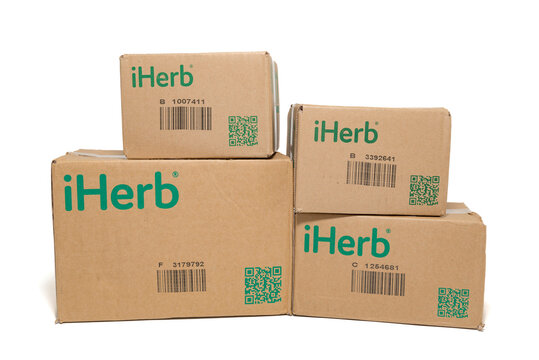 Fuji-shi, Shizuoka-ken, Japan - September 28, 2024: iHerb, online supplement and vitamin store - Cardboard packaging boxes isolated on white background